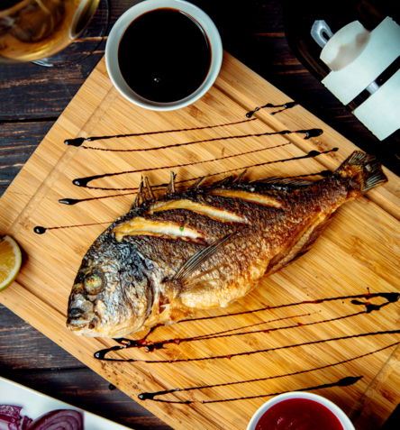 pescado-frito-sobre-tabla-de-madera-sobre-la-mesa.jpg